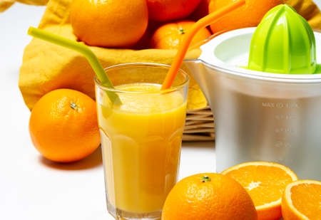 orange juice and squeezer with some orange aroundの写真素材