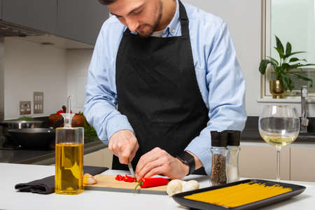 a man cooking italian pasta in the kitchenの写真素材
