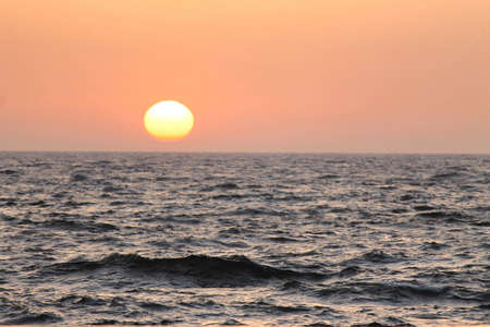 sun rising over the sea with a yellow backgroundの写真素材
