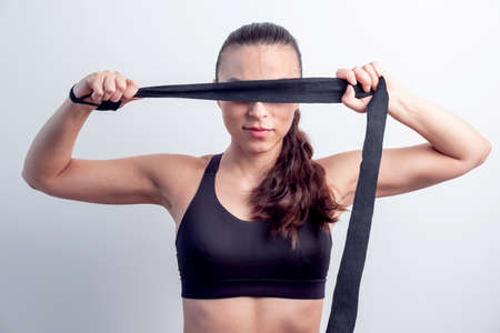 attractive woman cover her eyes with a black boxing bandの写真素材