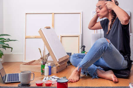woman listing music and painting at the meantimeの写真素材