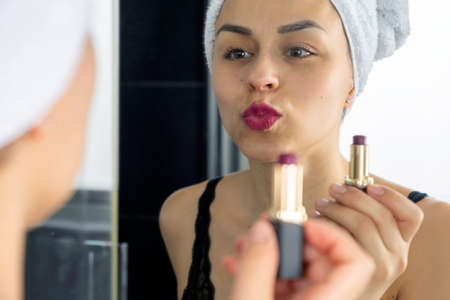 woman at the shower looking through the glass with some drop falling on the shower glassの写真素材