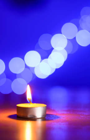 Tea candle and a bleu bokehの写真素材