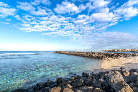 Jetty and beach at Terre Sainte village at Reunion Island during a sunny dayの写真素材