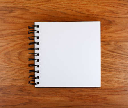 Notepad with a spiral binding on a wooden 