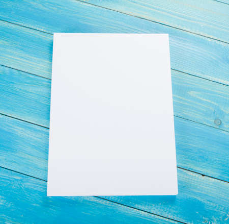 Blank flyer poster on wooden background to replace your designの写真素材