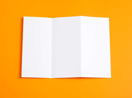 Blank folding page booklet on orange backgroundの写真素材