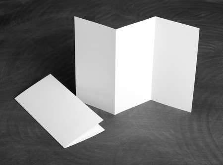 Identity design, corporate templates, company style, set of booklets, blank white folding paper flyer on a black chalkboardの写真素材