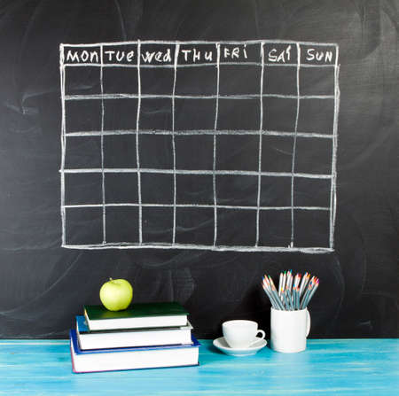Grid timetable schedule on black chalkboard backgroundの写真素材