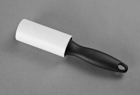 A lint brush with Black Handle used to remove excess fabric and particles from cloth on a grey backgroundの写真素材