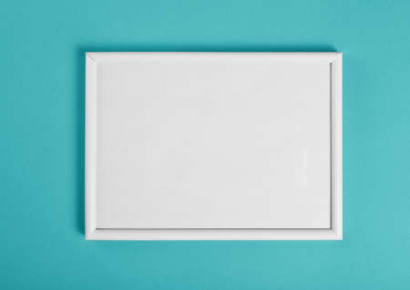 White wooden frame for painting or picture on green background. Top viewの写真素材