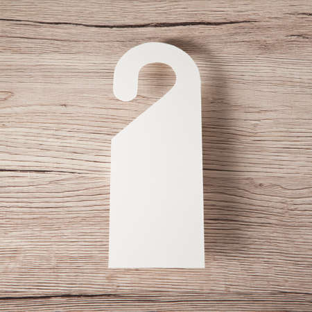 White door hanger on a wooden backgroundの写真素材