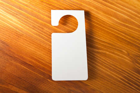 White door hanger on a wooden backgroundの写真素材