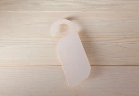 White door hanger on a wooden backgroundの写真素材