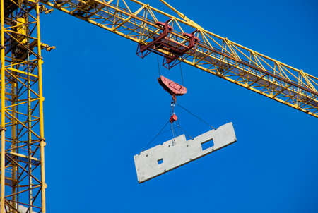 Tower crane at the construction site against the blue skyの写真素材