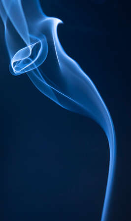Abstract blue smoke swirls on dark backgroundの写真素材