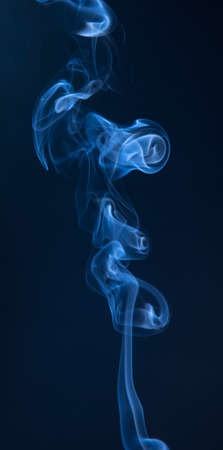Abstract blue smoke swirls on dark backgroundの写真素材
