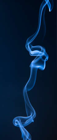 Abstract blue smoke swirls on dark backgroundの写真素材