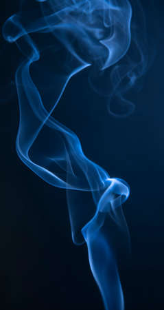 Abstract blue smoke swirls on dark backgroundの写真素材