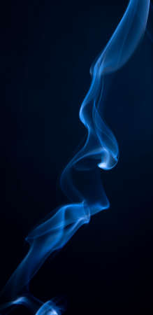 Abstract blue smoke swirls on dark backgroundの写真素材