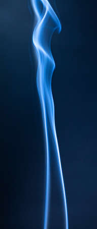 Abstract blue smoke swirls on dark backgroundの写真素材