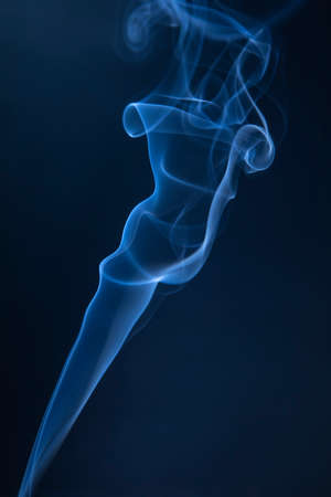 Abstract blue smoke swirls on dark backgroundの写真素材