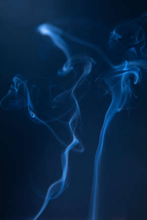 Abstract blue smoke swirls on dark backgroundの写真素材