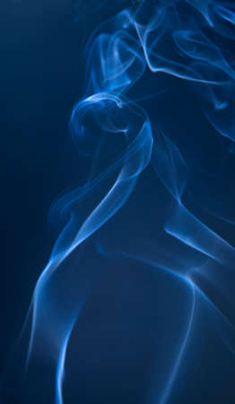Abstract blue smoke swirls on dark backgroundの写真素材