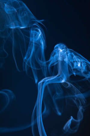 Abstract blue smoke swirls on dark backgroundの写真素材
