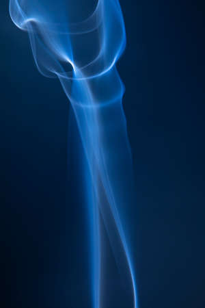 Abstract blue smoke swirls on dark backgroundの写真素材