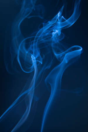 Abstract blue smoke swirls on dark backgroundの写真素材
