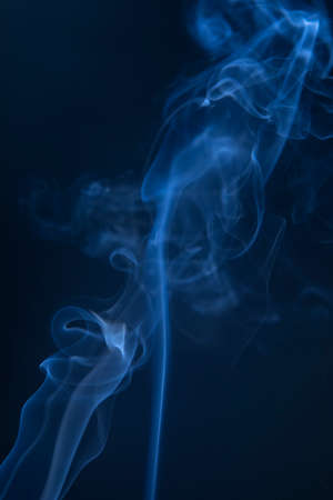 Abstract blue smoke swirls on dark backgroundの写真素材