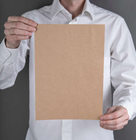 A man in a white shirt holding a blank letterhead