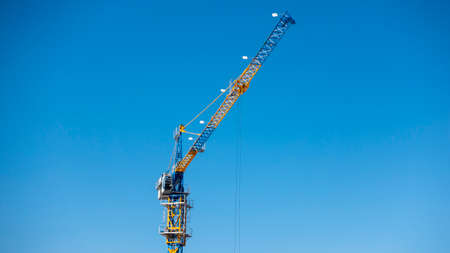 Tower crane at the construction site against the blue skyの写真素材