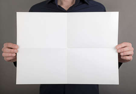 A man in a blue shirt holding a blank booklet
