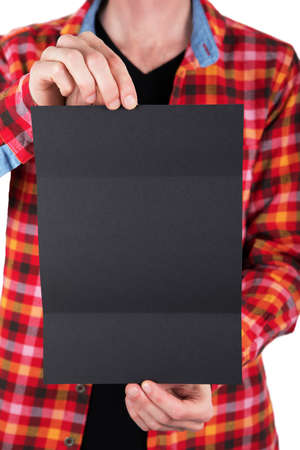 A man in a colored shirt holding a black booklet