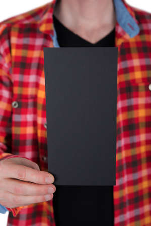 A man in a blue shirt holding a black flyerの写真素材