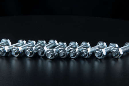 Nuts and bolts closeup on black backgroundの写真素材