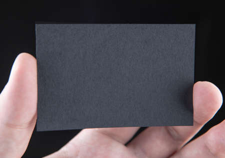 A man holding a black business card