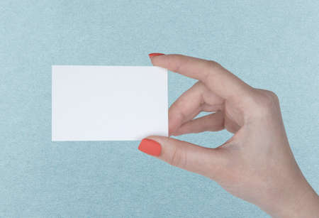 A woman holding a white business cardの写真素材