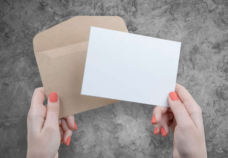 A woman holding a white business cardの写真素材