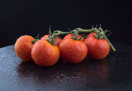 Tomatoes on the black cutting board.の写真素材