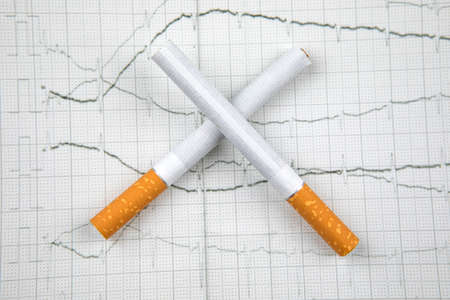Close up of a smoking cigarettes on whiteの写真素材