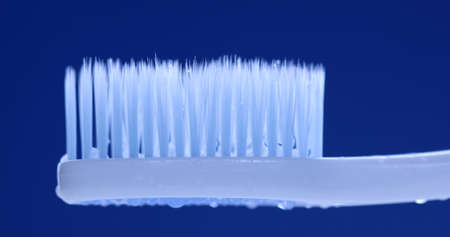 White toothbrush on blue background. Close up