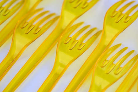 Yellow plastic forks isolated on white backgroundの写真素材