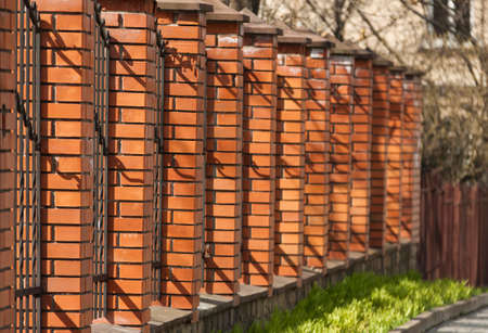 High fence with brick columns. Decorative hedgeの写真素材