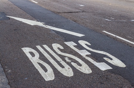 White bus lane sign on the tarmac street