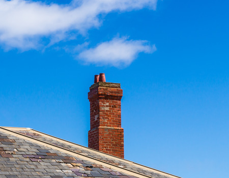 The old brick chimney on the roof in the countrysideの写真素材
