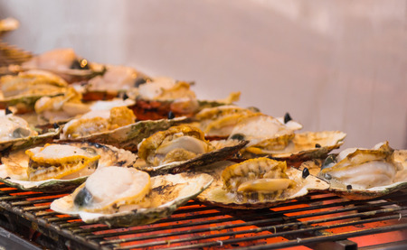 Grilled seafood on seashells at the marketの写真素材