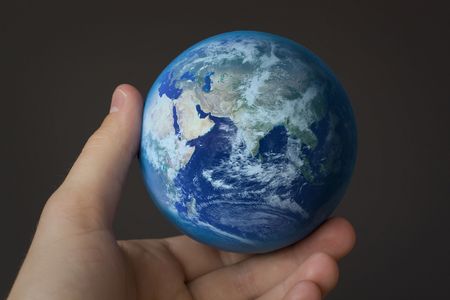 holding the world in my hand in front of a gray backgroundの写真素材